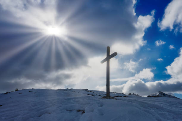 istock Christian Cross silhouette sunlight clouds sky 1124863350