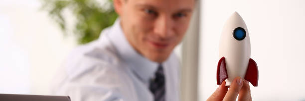istock Businessman in suit hold white rockrt in hand 1124867083