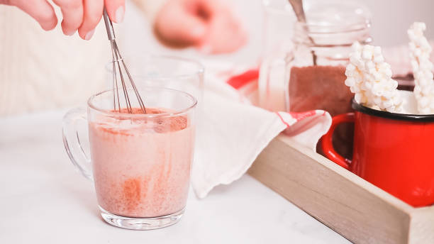 istock Mixing hot chocolate mix in glass cup with with small whisk. 1124870074