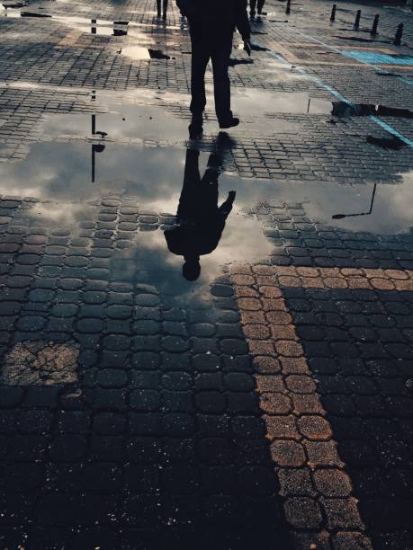 istock Water reflection of man walking in the street 1124872111