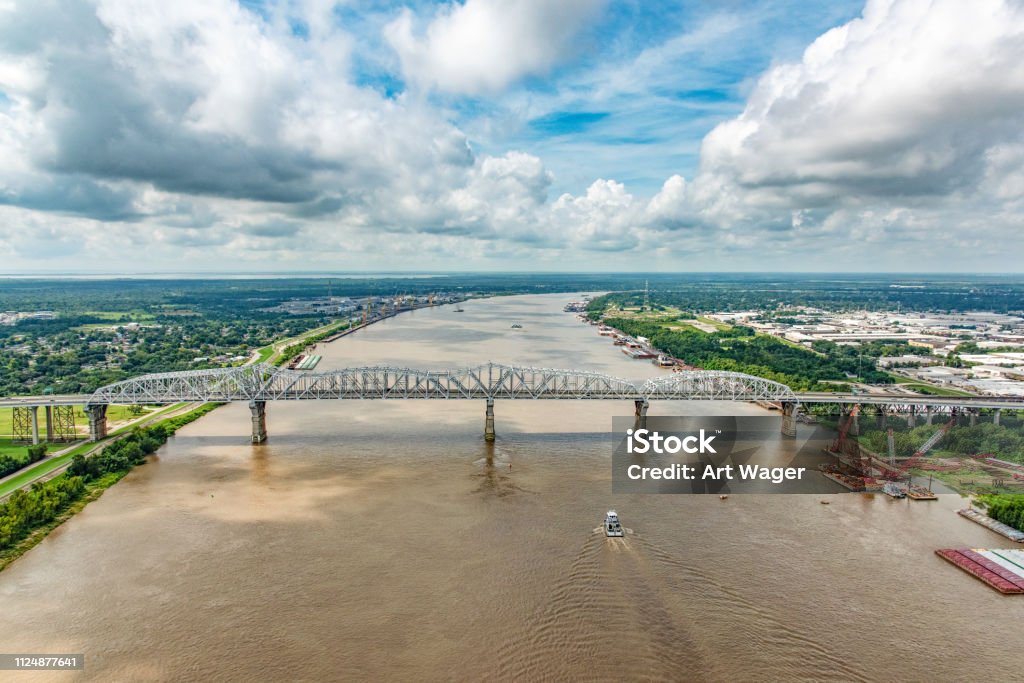 Bridge Spanning the Mississippi River A bridge supporting both vehicles and a railway crossing the Mississippi River which is flanked on both sides by various industry located just north of New Orleans, Louisiana, shot from an altitude of about 600 feet over the river. Mississippi River Stock Photo