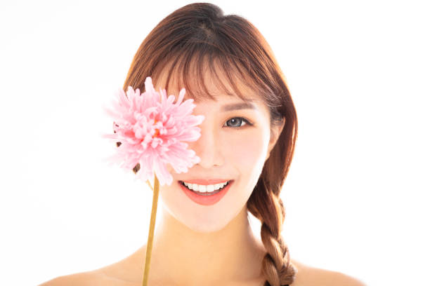 istock closeup young smiling beauty face with flower 1124881856
