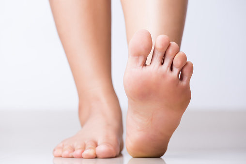 Feet of a senior citizen with large nails.