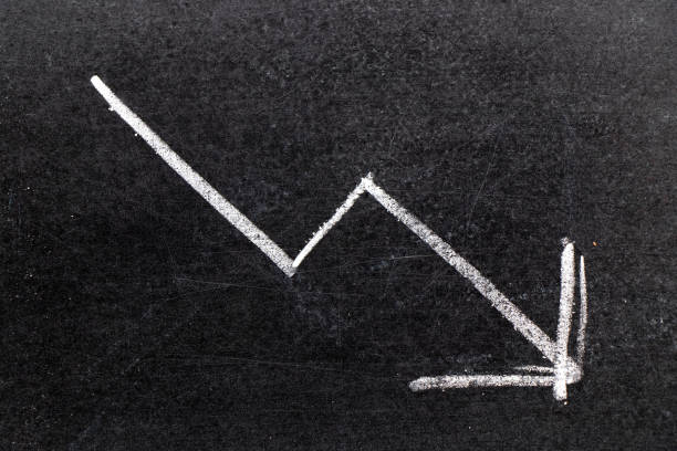 istock White chalk hand drawing in arrow down shape on black board background (Concept of stock decline, down trend of business, economy) 1124913891