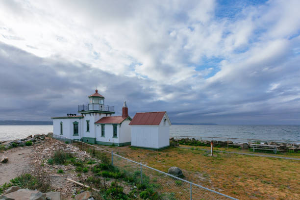 istock Victorian-era lighthouse under clouds by water in Discovery Park, Seattle, USA 1124933544