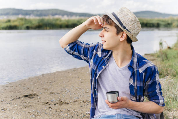 istock hiker is taking a break and drinking tea or coffee from a thermos 1124934176