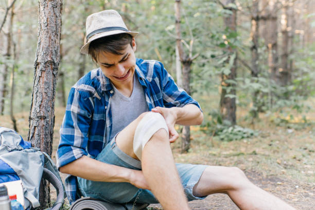 istock hiker applying a bandage in a forest during the hike 1124934994