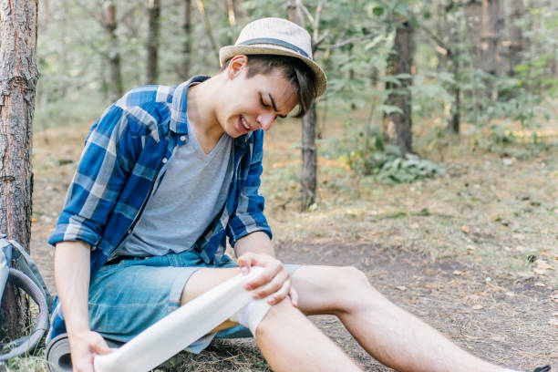 istock hiker applying a bandage in a forest during the hike 1124935012