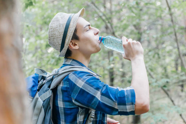 istock male hiker taking a break and drinking water from bottle 1124935396