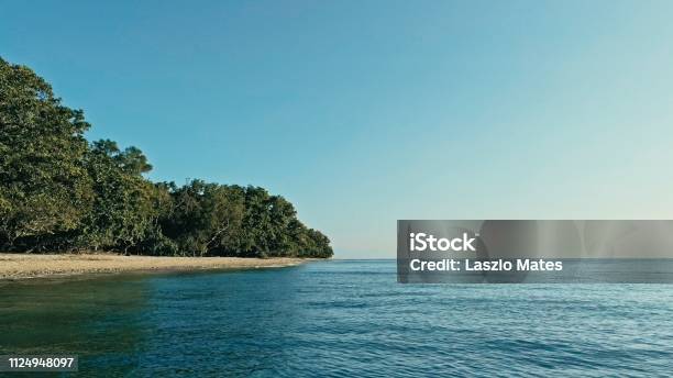 Aerial Drone Image Of A Remote South Pacific Island With Sandy Beach Shore And Beautiful Ocean Sea Seascape And Lush Tropical Rainforest Jungle Stock Photo - Download Image Now