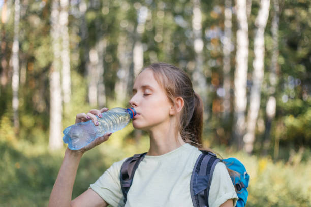 istock Hiker tourist girl is drinking water from a bottle 1124949701