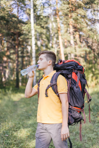 istock Hiker tourist guy is drinking water from a bottle 1124949843