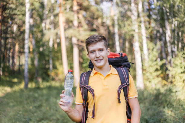 istock Hiker tourist guy is drinking water from a bottle 1124949913