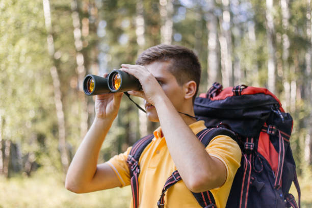 istock Hiker guy is looking in binoculars enjoying spectacular view 1124949970