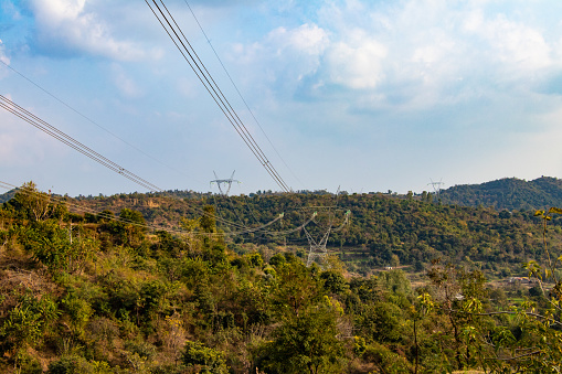 High voltage tower, electric transmission tower in hill area. Electricity distribution tower on top of hill