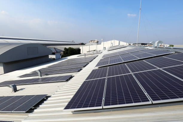 energía solar fotovoltaica sobre techo industrial con chimeneas de conducto de escape - solar system fotografías e imágenes de stock