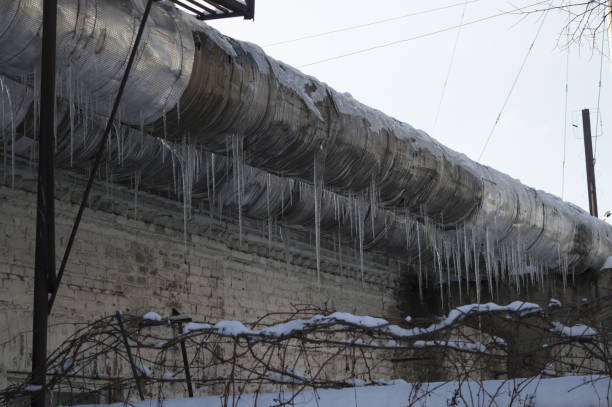 istock Industrial thick pipe in a plant with large icicles in winter 1124959435