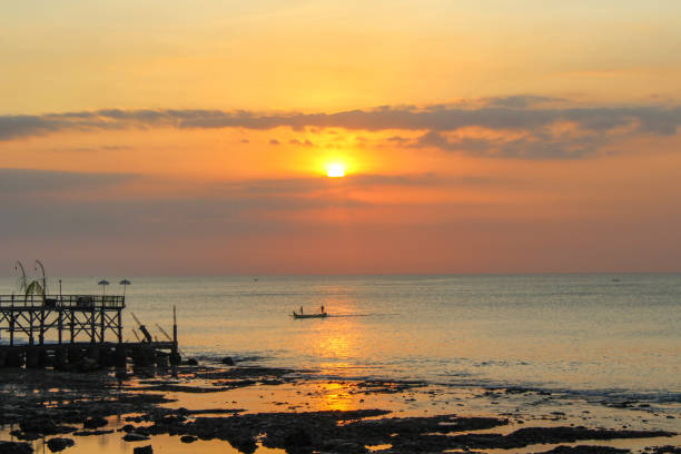 pôr do sol de bali, jimbaran, indonésia - indonesia bali fishing boat indian ocean - fotografias e filmes do acervo