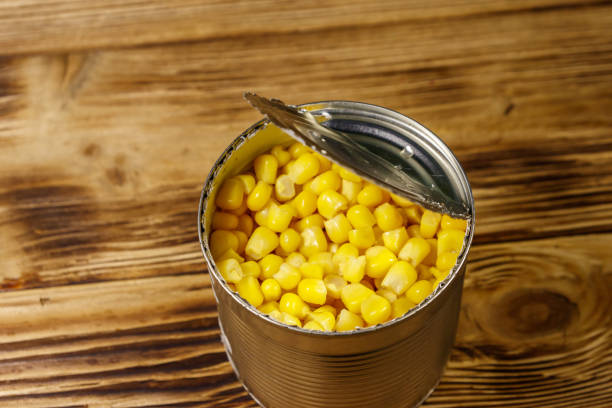 istock Open tin can of corn on wooden table 1124962767