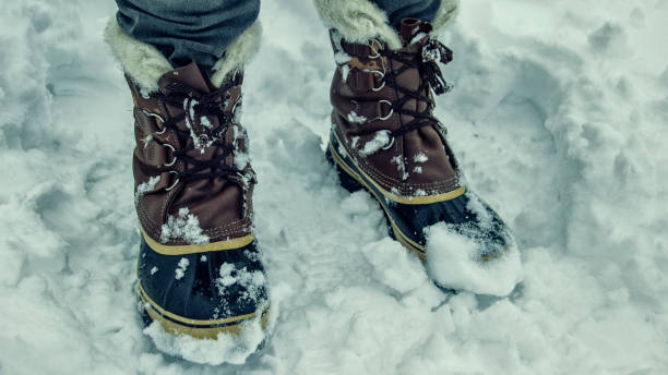 istock Warm winter boots with fur on snow background 1124962904