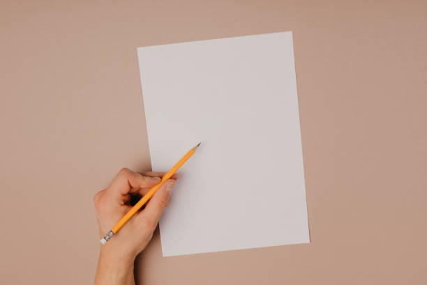 istock Hands writing on paper blank a4 size on grey background. 1124963283
