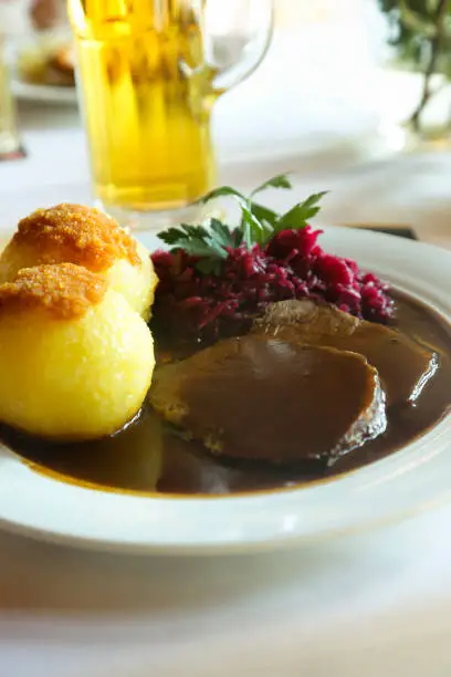 German style meat stew with dumplings and red cabbage
