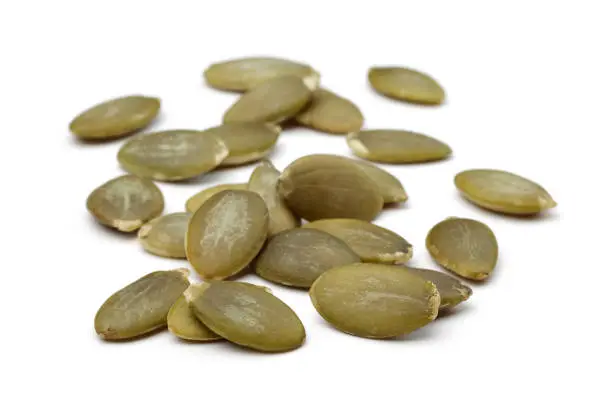 Heap of peeled pumpkin seeds isolated on white background