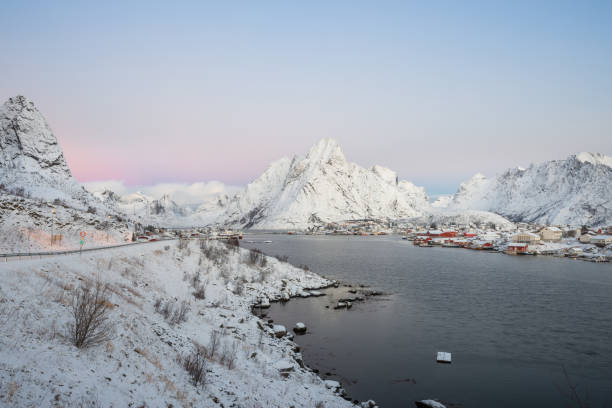 krajobraz dishing dom wsi wśród śniegu z widokiem na góry w lofotów wyspa reine norwegii - dishing out zdjęcia i obrazy z banku zdjęć
