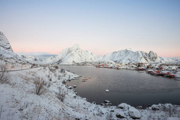 krajobraz dishing dom wsi wśród śniegu z widokiem na góry w lofotów wyspa reine norwegii - dishing out zdjęcia i obrazy z banku zdjęć