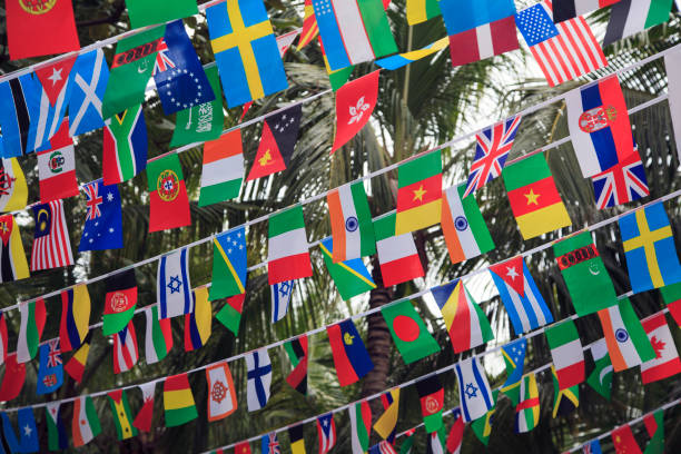 istock World flags,little flags of different countries, small flags of different countries stretched between palm trees 1124978439