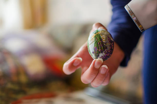Overhead view on little girl hand painting easter  eggs on old blue vintage background