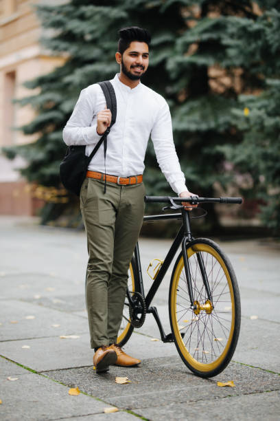 istock Young handsome asian business man with backpack walking down the street pushing bicycle while going to work. 1124982813