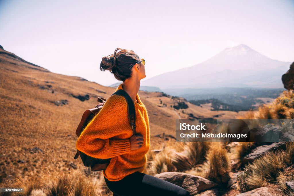 Enjoying the view. Young Latin woman enjoying the view to Popocatepetl volcano Travel Stock Photo