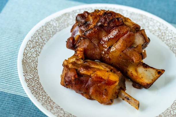 Two pieces of grilled pork knee with bone.