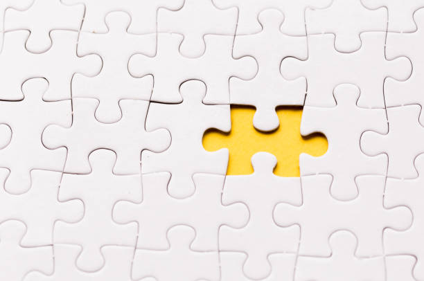 istock Unfinished white jigsaw puzzle pieces. One missing jigsaw piece on yellow background 1124986168