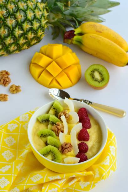 istock Mango banana pineapple smoothie bowl topped with raspberry, kiwi, walnut and coconut chips 1124988910