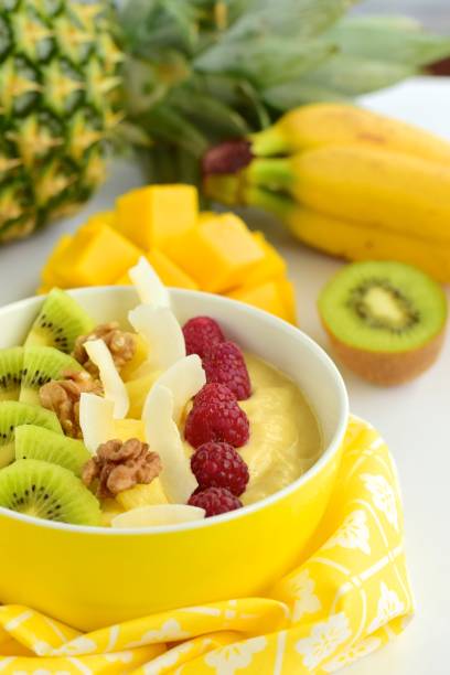 istock Mango banana pineapple smoothie bowl topped with raspberry, kiwi, walnut and coconut chips 1124989344