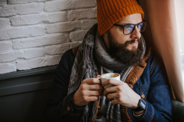 istock Attractive young man drinking coffee at cafe 1124991468