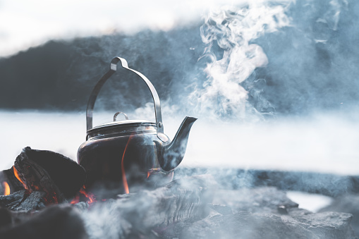 Close-up of a kettle boiling coffee by a campfire. Shot in Sweden on a cold winter afternoon.