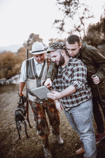 Group of Hunters Looking for GPS Coordinates on Tablet in Nature