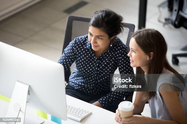 Multirraciales Colegas Sentados Juntos Mirando La Pantalla Del Ordenador Portátil En La Oficina Foto de stock y más banco de imágenes de Aprendiz