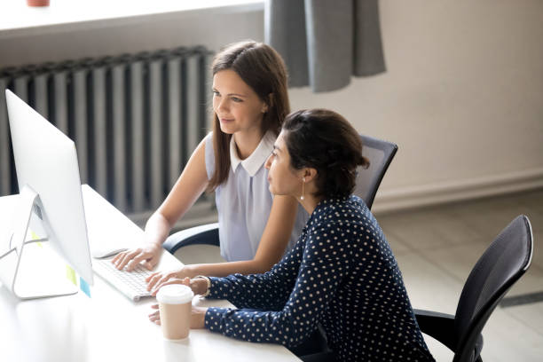 Multiracial colleagues working sitting in office at the desk