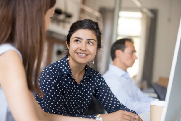 istock Multiracial colleagues communicating sitting in office at the desk 1124997270