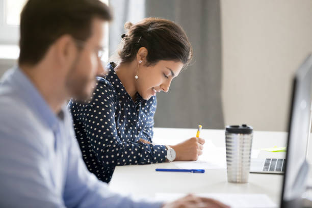 Multiracial people sitting at desk working in office