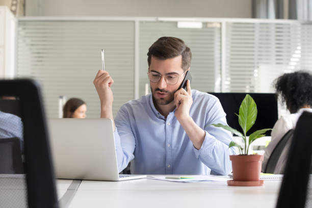 istock Employee working in coworking area taking by phone 1124997396
