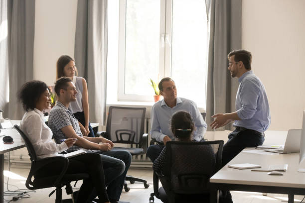 istock Company owner talking with diverse employees at meeting 1124997445