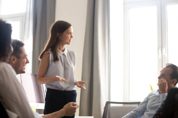 istock Coach discussing with diverse workers during business meeting 1124997470
