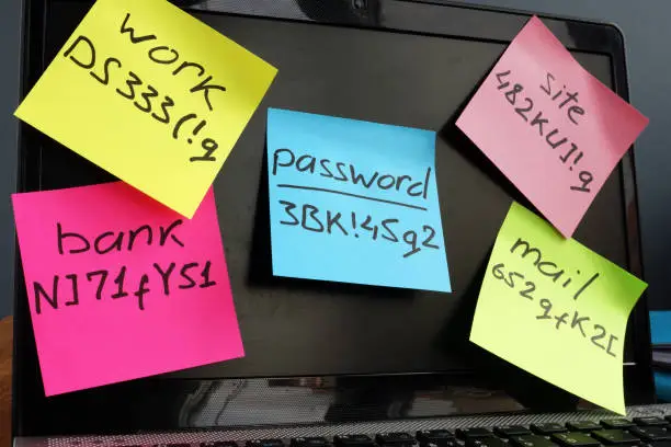 Photo of Password management. Laptop with memo sticks on the screen.