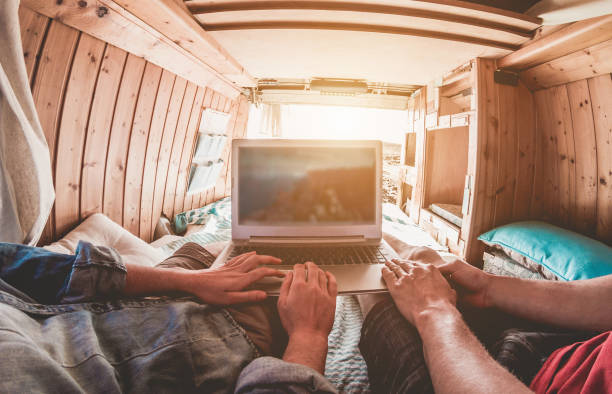 istock Digital nomad couple working inside minivan with wood interiors 1125007660