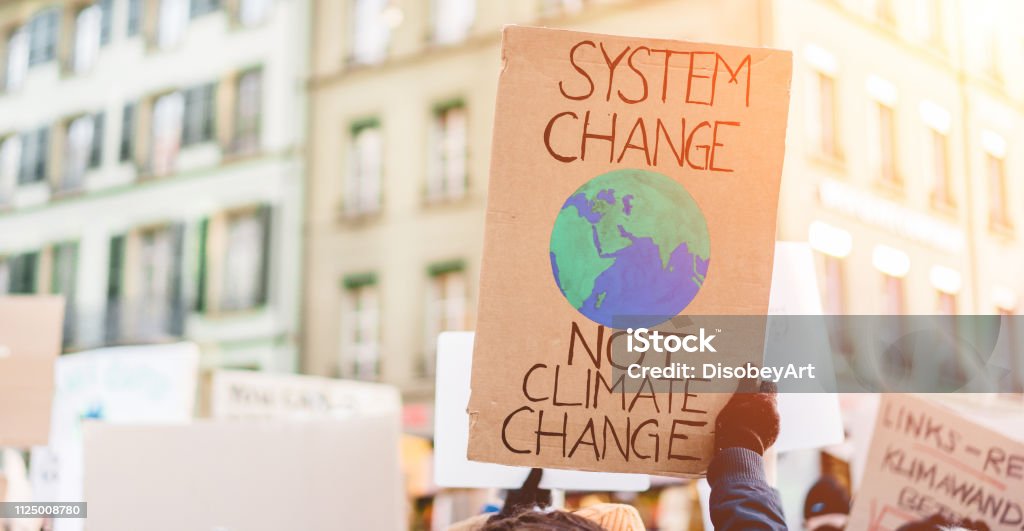 Group of demonstrators on road, young people fight for climate change - Global warming and enviroment concept - Focus on banner Climate Change Stock Photo